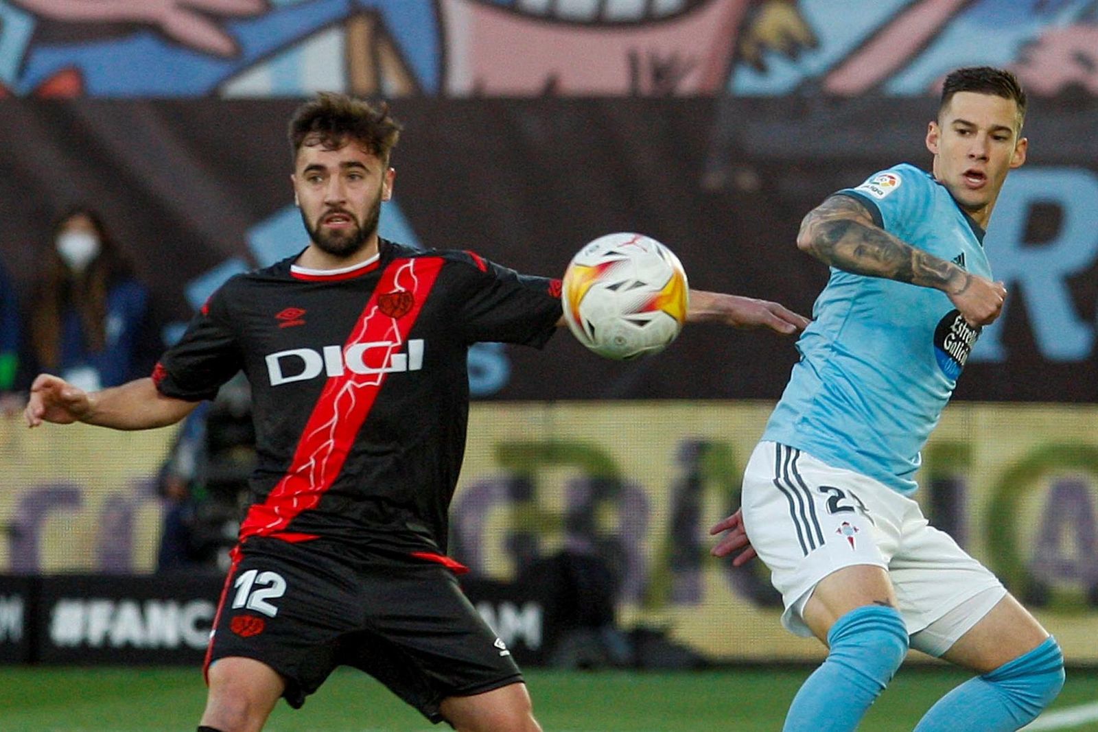 El delantero del Celta Santi Mina pelea un balón con Unai López del Rayo Vallecano,