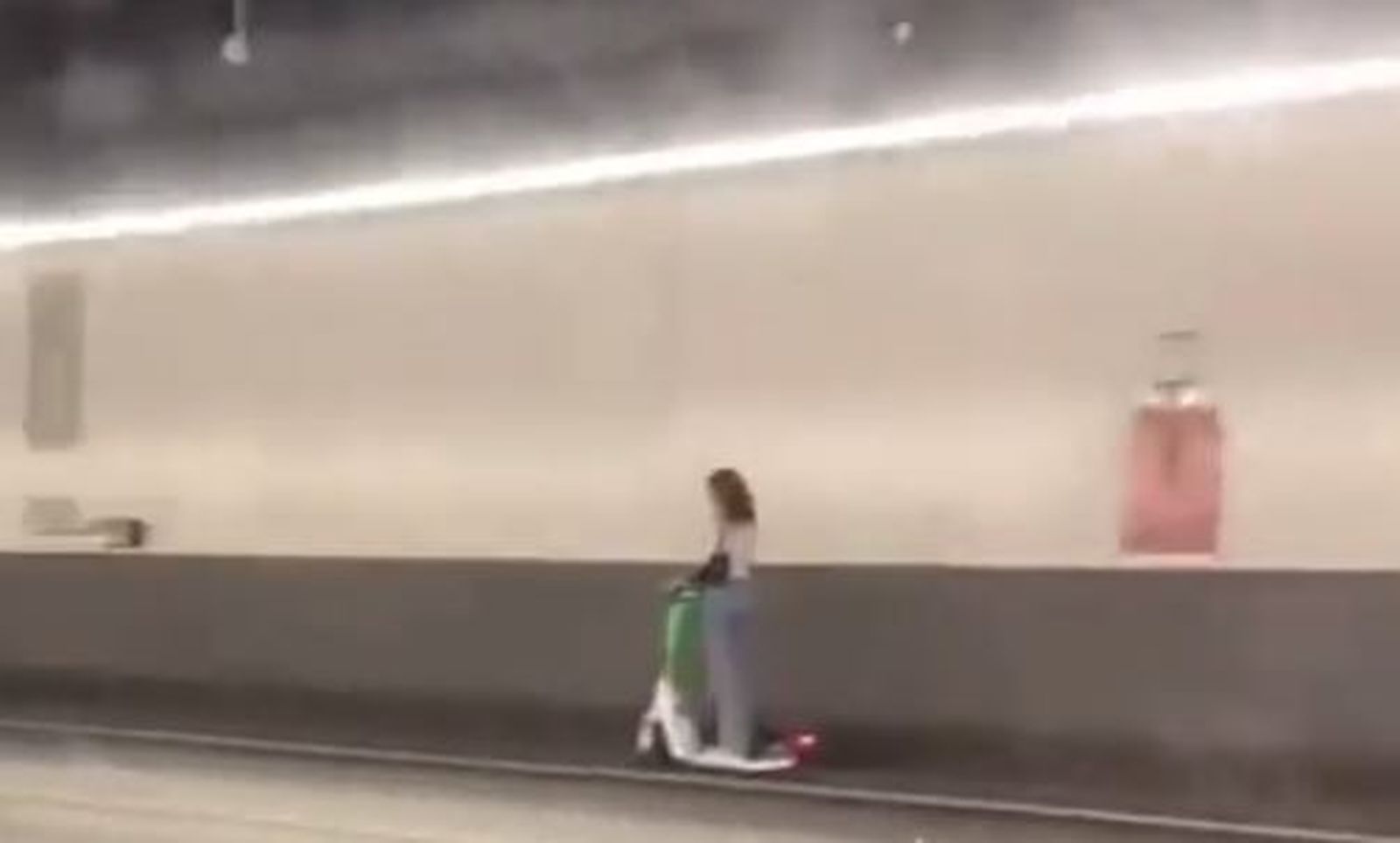 Una joven circula en un patinete por el túnel de la M-30