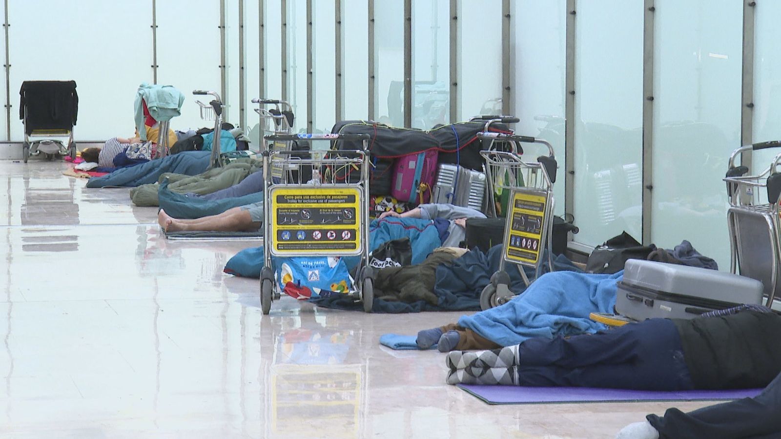 Personas sin hogar duermen en una terminal de Barajas
